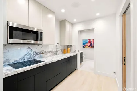 a kitchen with sink a microwave and refrigerator