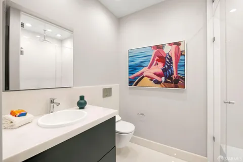a bathroom with a sink mirror vanity and toilet