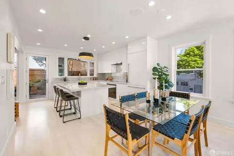 a kitchen with a table chairs refrigerator and cabinets