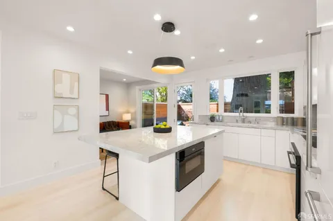 a kitchen with stainless steel appliances granite countertop a sink a stove and a refrigerator