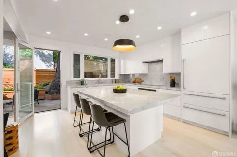 a kitchen with stainless steel appliances granite countertop a sink a stove and a refrigerator