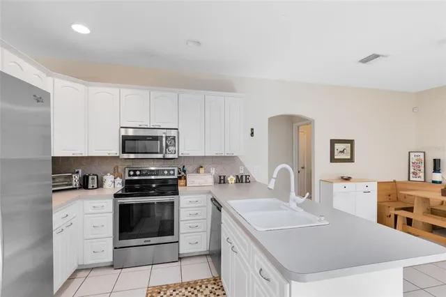 a kitchen with stainless steel appliances a stove a sink a microwave a refrigerator and cabinets