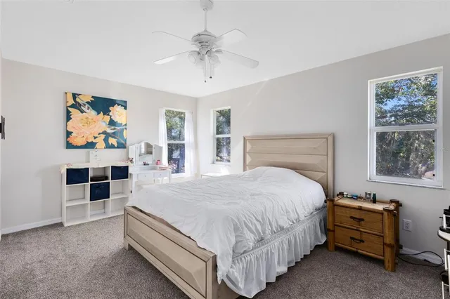 a bedroom with a bed and a flat tv screen on the dresser
