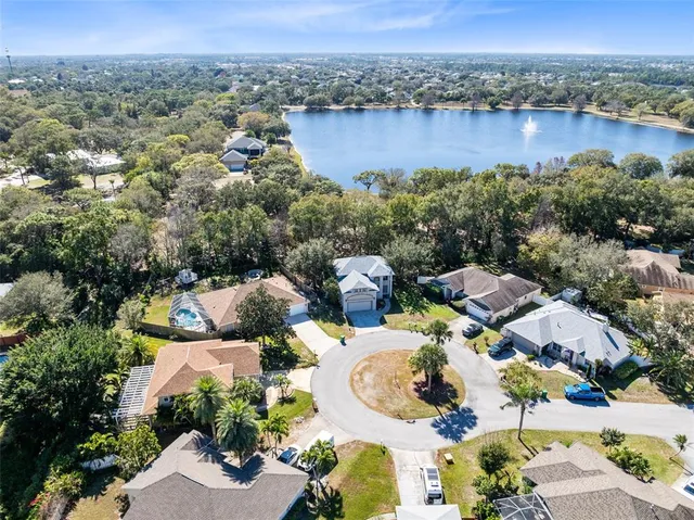 an aerial view of a house with a garden and lake view