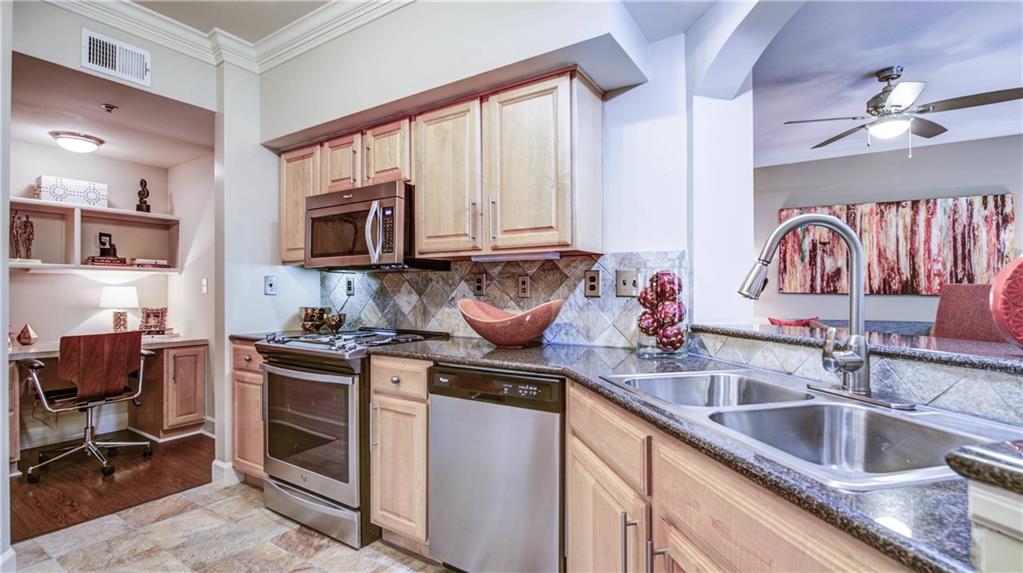 a kitchen with stainless steel appliances granite countertop a sink stove and cabinets