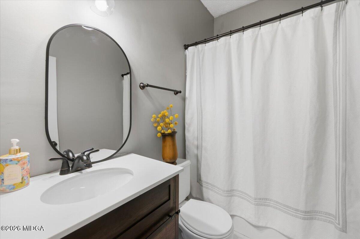 1608 Rumble Road Forsyth, GA 31029 - Photo 34 of 46 a bathroom with a sink a toilet and shower curtain