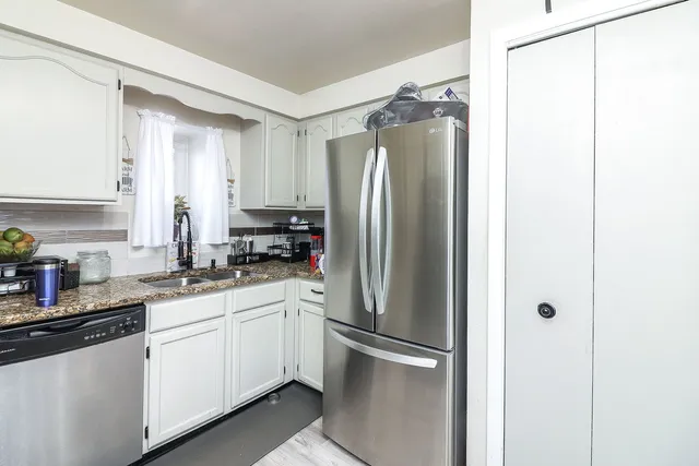 a kitchen with a refrigerator a sink and cabinets
