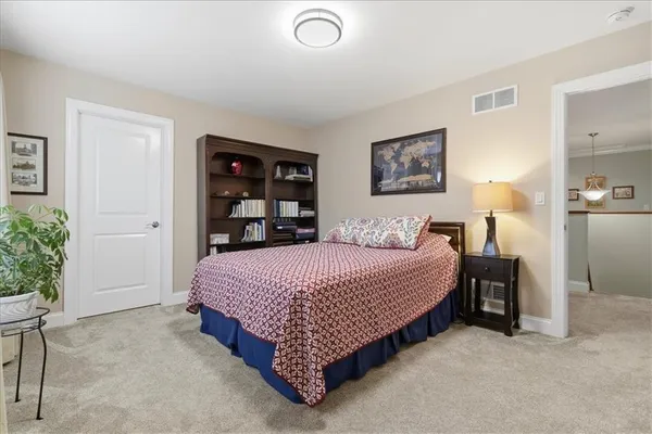 a bedroom with bed and painting on the wall