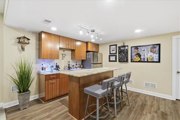 a large room with kitchen view and wooden floor