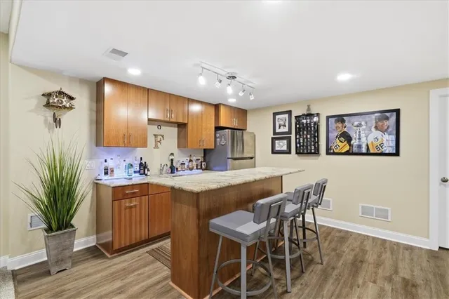 a large room with kitchen view and wooden floor