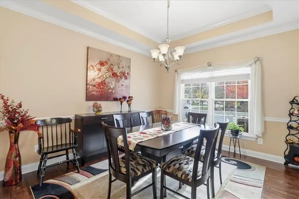 a kitchen with stainless steel appliances granite countertop a stove top oven a sink a stove a dining table and chairs