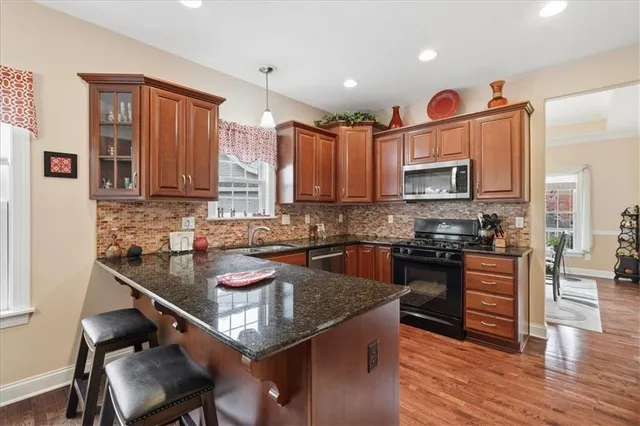 a kitchen with stainless steel appliances granite countertop a stove a sink and a granite counter tops