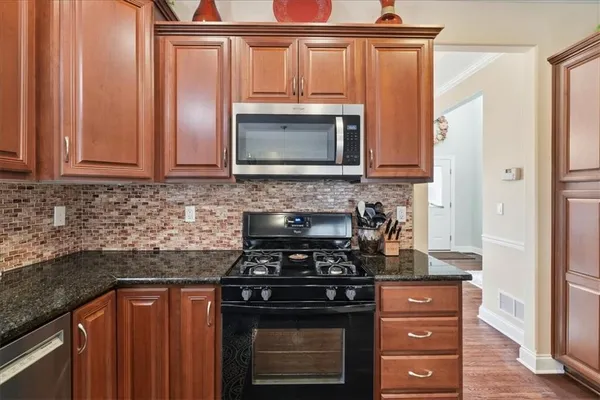 a kitchen with stainless steel appliances granite countertop a refrigerator and a sink