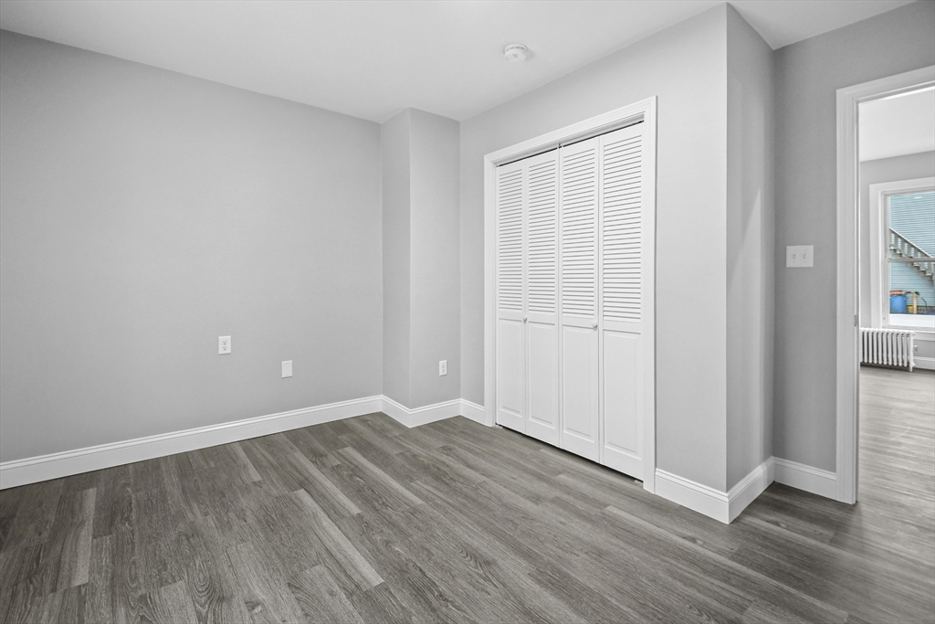 509 High Street Clinton, MA 01510 - Photo 15 of 42 an empty room with wooden floor and windows