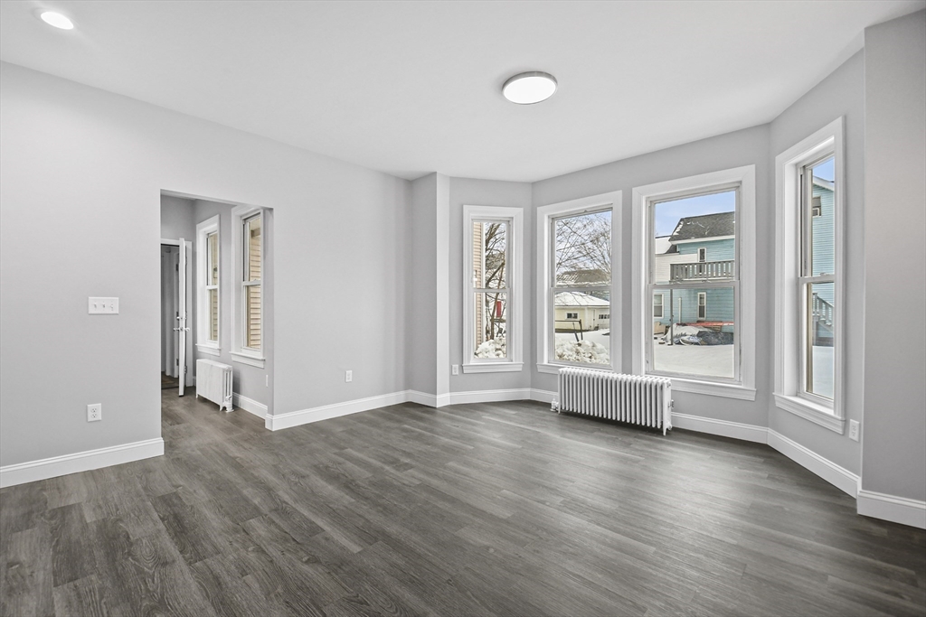 509 High Street Clinton, MA 01510 - Photo 3 of 42 an empty room with wooden floor and windows