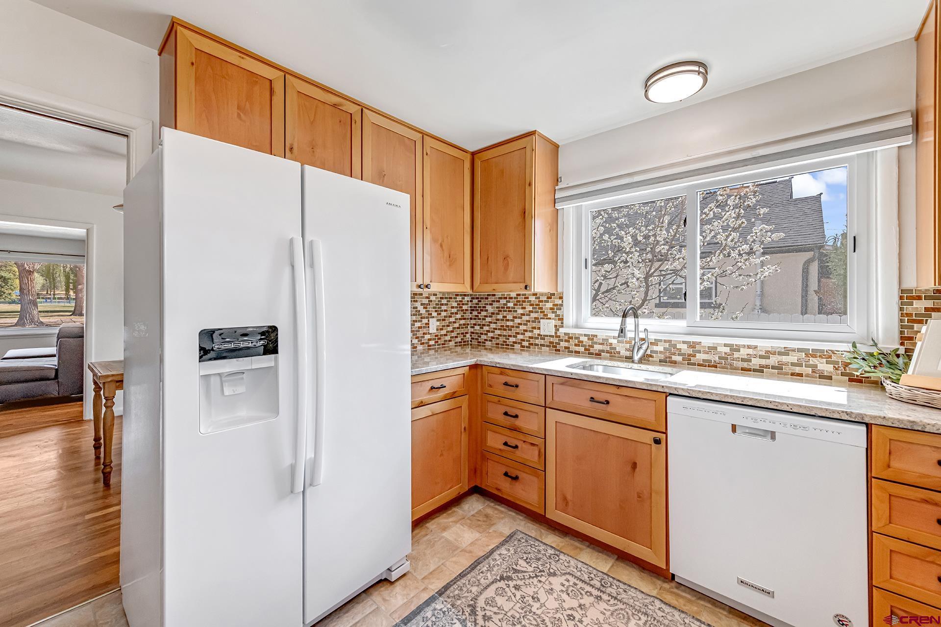 735 Howard Street Delta, CO 81416 - Photo 14 of 34 a kitchen with stainless steel appliances a refrigerator sink and cabinets