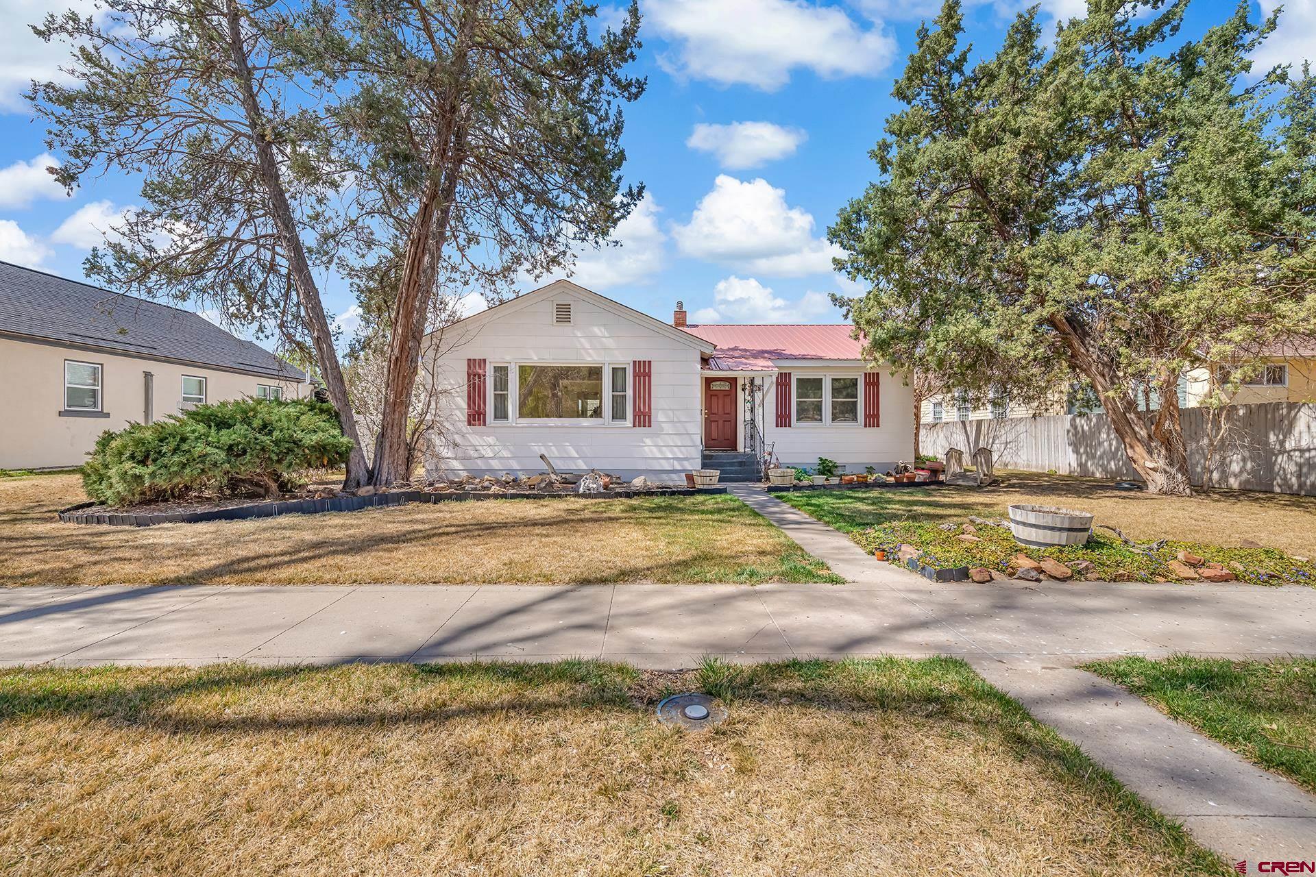 735 Howard Street Delta, CO 81416 - Photo 2 of 34 a view of a house with a yard and large trees