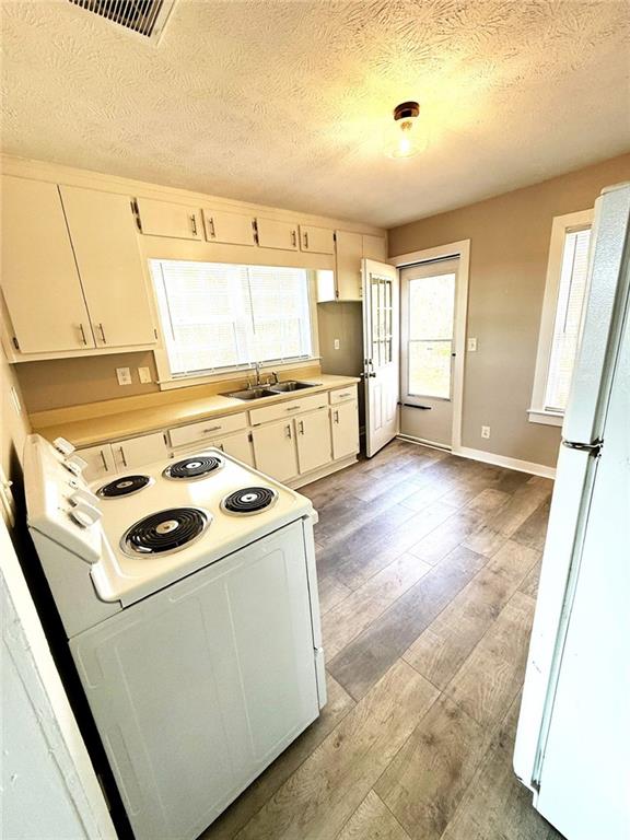 343 Chastain Mill Road Dawsonville, GA 30534 - Photo 4 of 12 a kitchen that has a microwave a sink and a stove in it