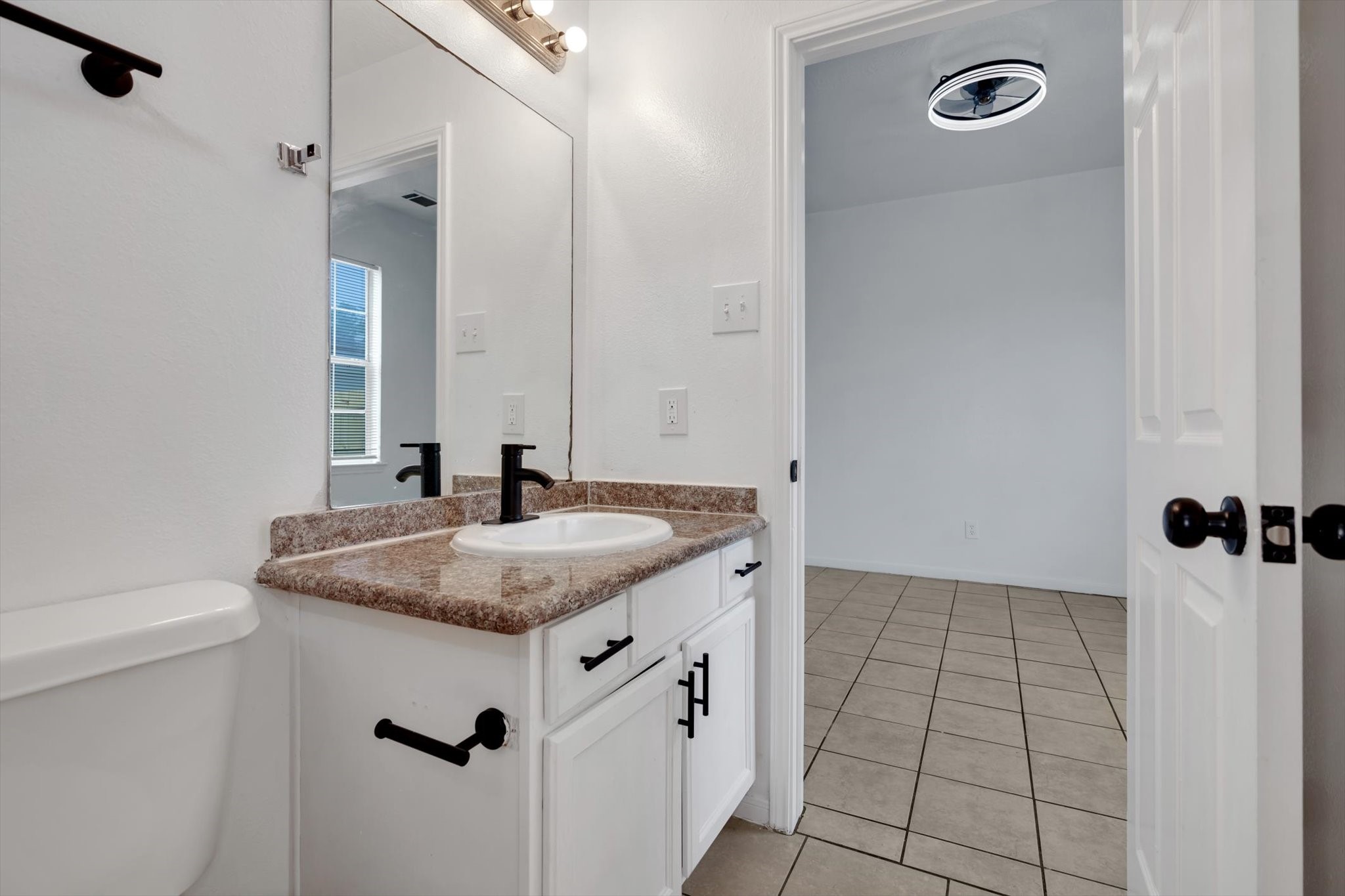 6933 Liverpool Street, Unit A Houston, TX 77021 - Photo 29 of 49 a bathroom with a granite countertop sink a mirror and shower