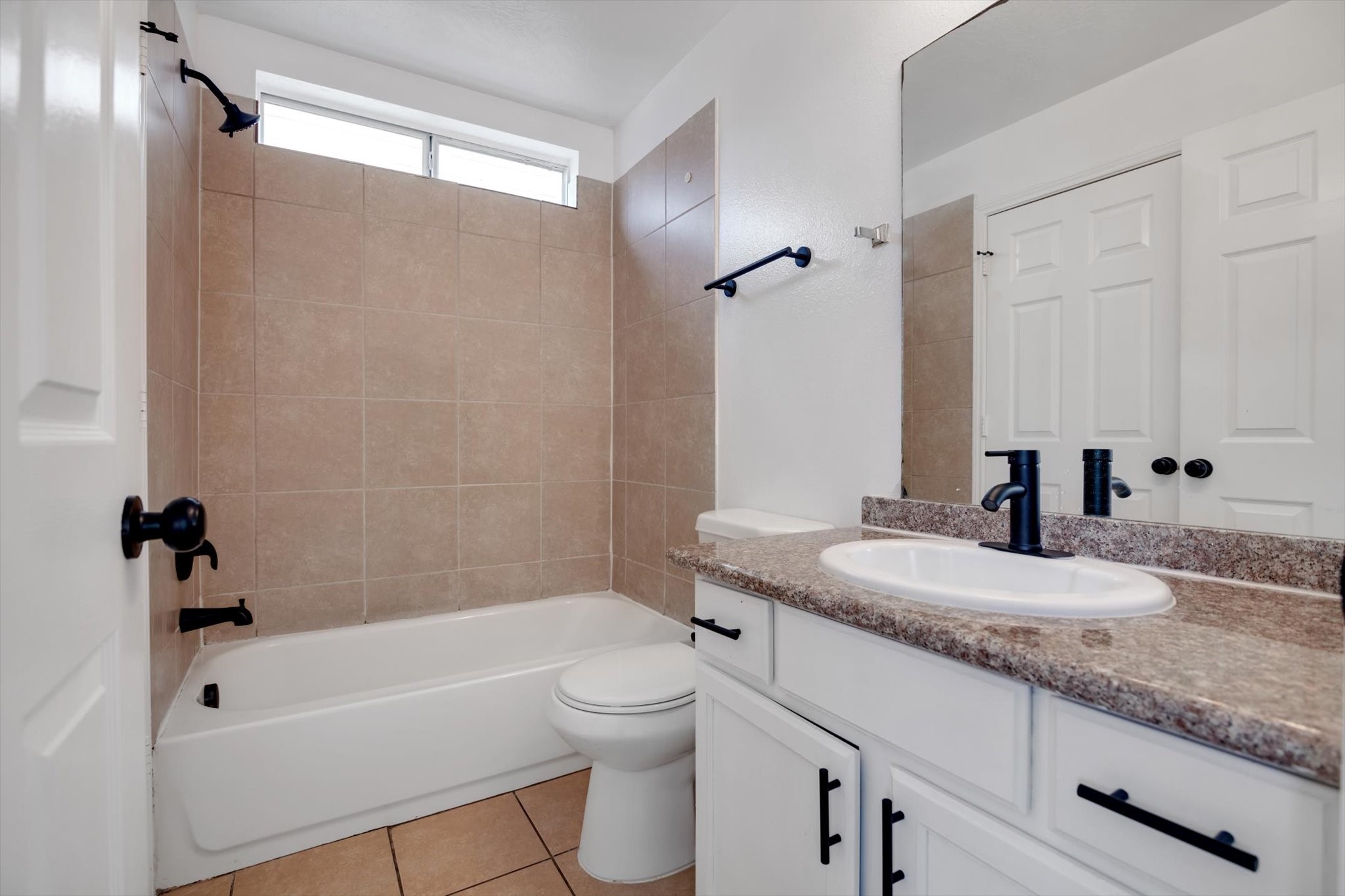 6933 Liverpool Street, Unit A Houston, TX 77021 - Photo 43 of 49 a bathroom with a granite countertop sink a toilet a mirror a bathtub and shower
