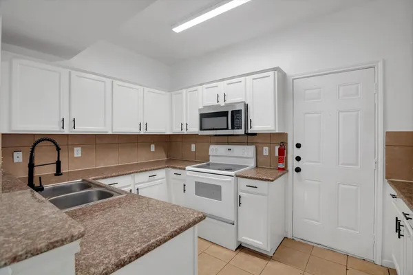 a kitchen with stainless steel appliances granite countertop a sink and a stove