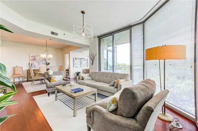 a living room with furniture a flat screen tv and a chandelier