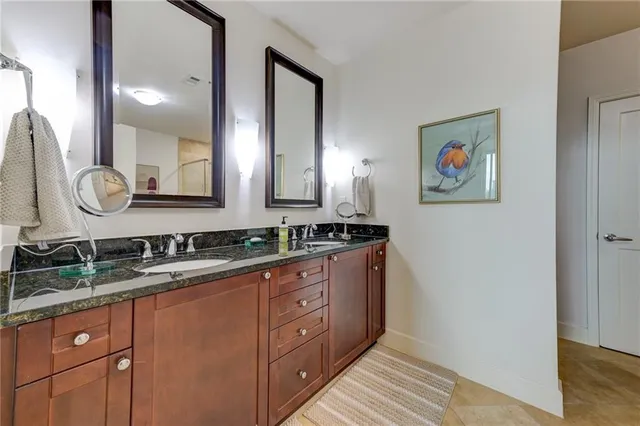 a bathroom with double vanity and a mirror