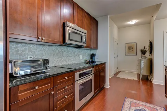 a kitchen with stainless steel appliances granite countertop wooden cabinets a stove a sink and dishwasher