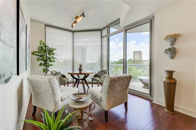 a dining room with furniture potted plants and wooden floor