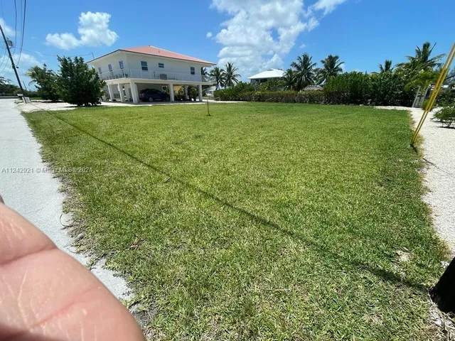 a car parked in front of a house with a big yard