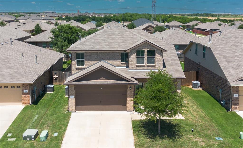 753 Rutherford Drive Crowley, TX 76036 - Photo 3 of 26 Two-story brick facade residence featuring a two-car garage, pitched shingle roof, and a mature tree in the front yard