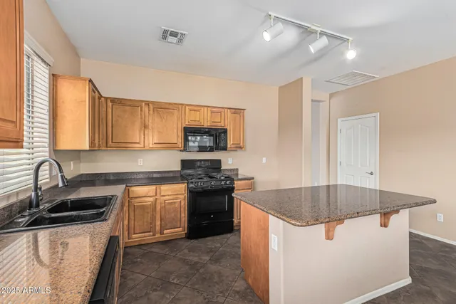 a bathroom with a granite countertop sink a mirror a bathtub and shower