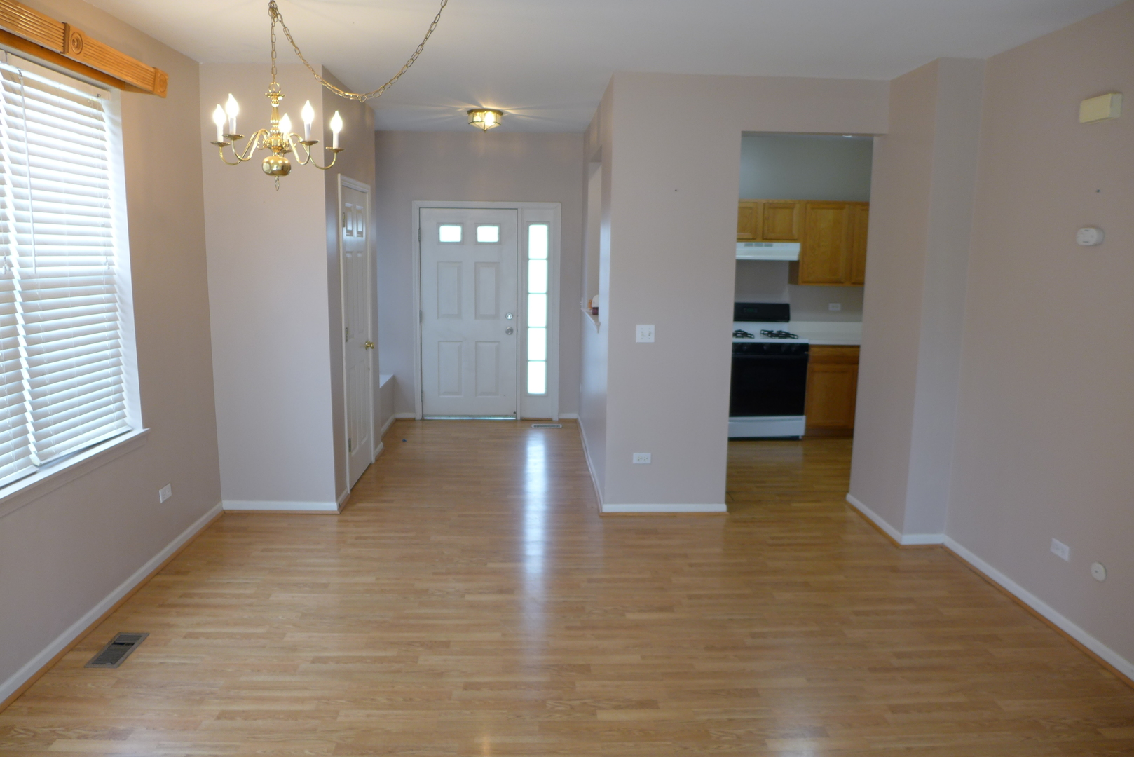 3076 Falling Waters Lane Lindenhurst, IL 60046 - Photo 6 of 15 a view of a hallway with wooden floor and chandelier
