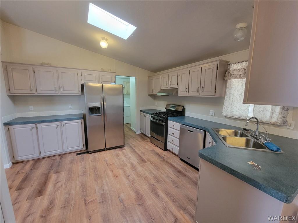 3469 Bouse Road Golden Valley, AZ 86413 - Photo 19 of 37 a kitchen with stainless steel appliances granite countertop a refrigerator a sink a stove a microwave and wooden cabinets