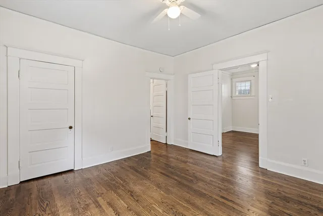 an empty room with wooden floor and closet area