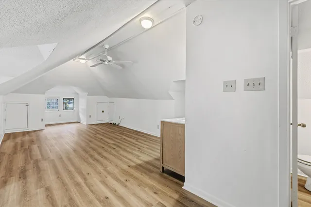 a view of empty room with wooden floor