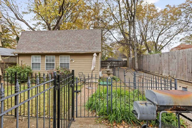 a view of a white house with a large window and potted plants