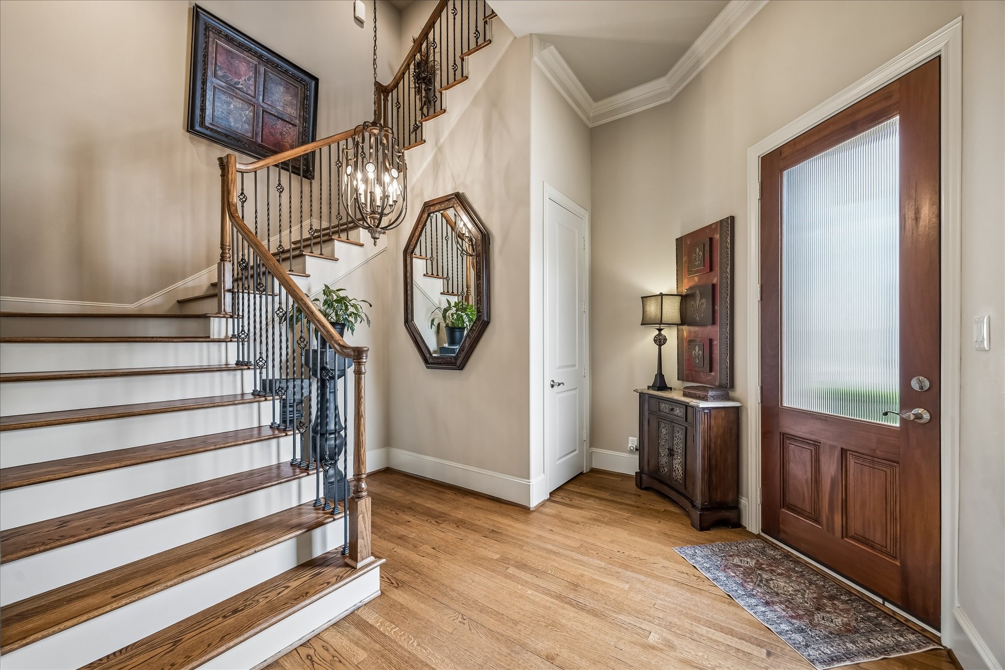 907 Queen Annes Road Houston, TX 77024 - Photo 2 of 31 Grand entry foyer featuring soaring ceilings, hardwood flooring, elegant staircase detailing, elevator capability, and conveniently located first-floor powder bath.