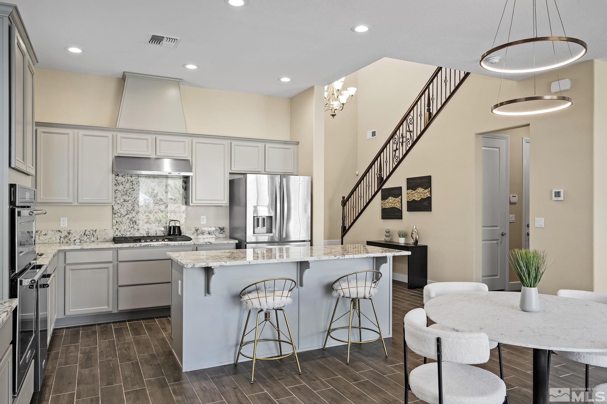 2995 Bonfire Lane Reno, NV 89521 - Photo 15 of 40 a kitchen with stainless steel appliances a dining table chairs stove and white cabinets