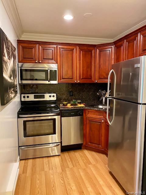 99 Prospect Street, Unit 5A Babylon, NY 11702 - Photo 2 of 5 a kitchen with stainless steel appliances granite countertop a stove a sink and a microwave