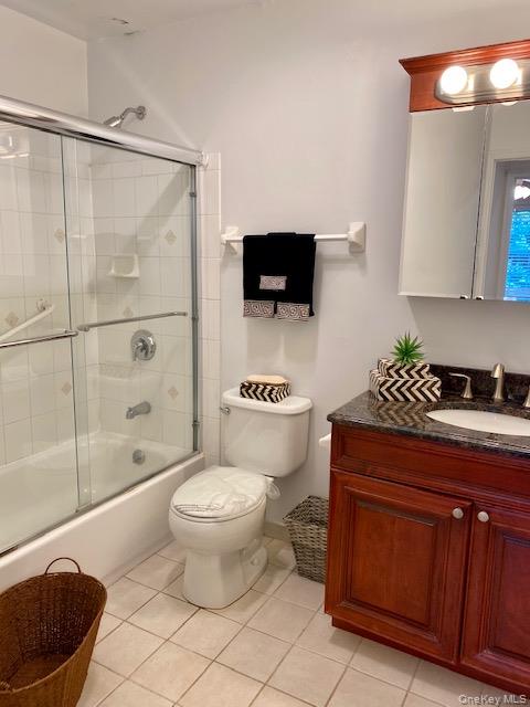 99 Prospect Street, Unit 5A Babylon, NY 11702 - Photo 5 of 5 a bathroom with a granite countertop sink a toilet a mirror and shower