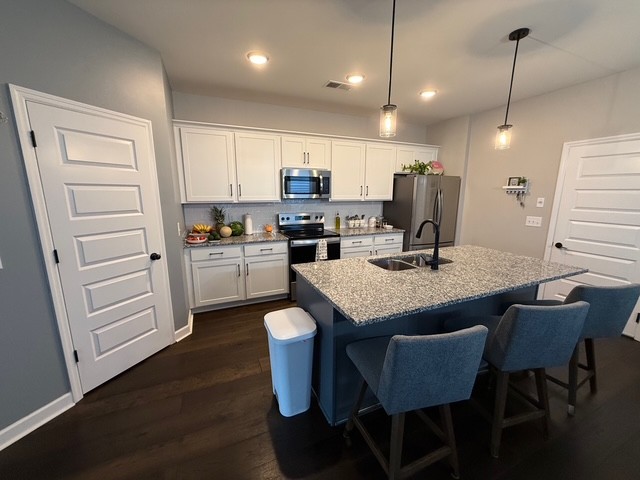 1737 Fenway Loop Antioch, TN 37013 - Photo 4 of 33 a kitchen with kitchen island granite countertop a sink cabinets and wooden floor
