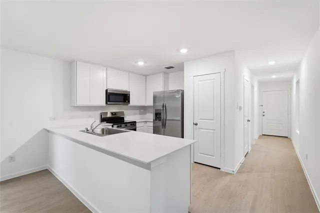 a kitchen with stainless steel appliances a sink and a refrigerator