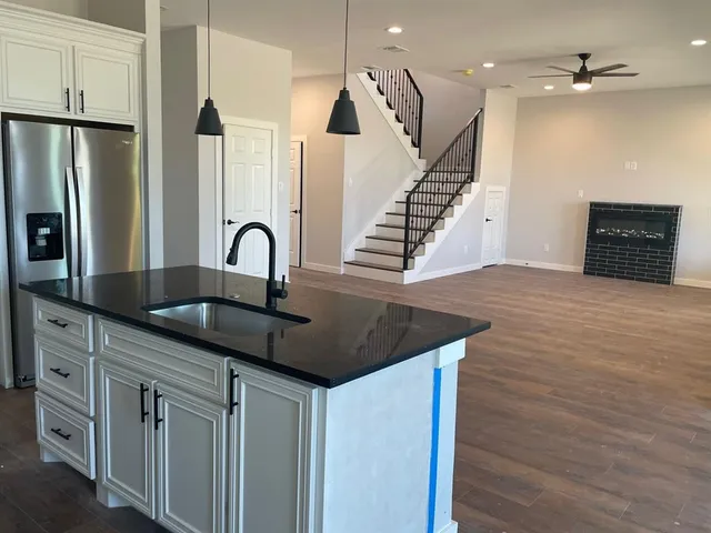 a kitchen with stainless steel appliances granite countertop a sink a stove and a refrigerator