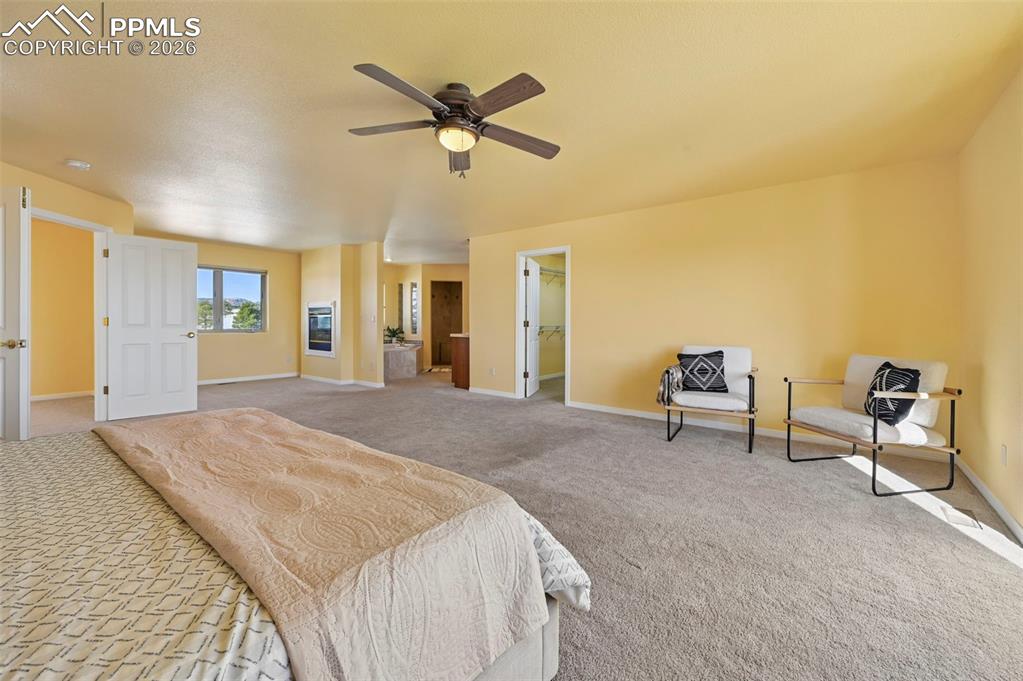 19610 Rathbone Circle Monument, CO 80132 - Photo 21 of 41 a spacious bedroom with a bed and a chandelier