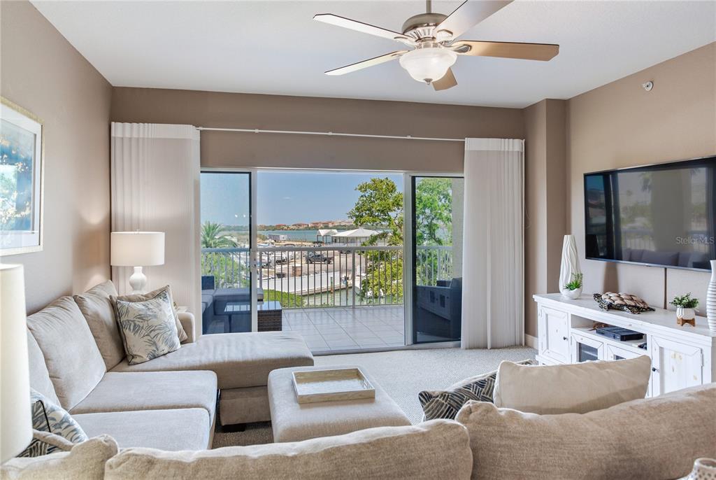 425 150th Avenue, Unit 2301 Madeira Beach, FL 33708 - Photo 13 of 67 a living room with furniture and a flat screen tv