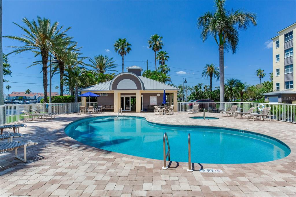 425 150th Avenue, Unit 2301 Madeira Beach, FL 33708 - Photo 52 of 67 a swimming pool with outdoor seating and yard