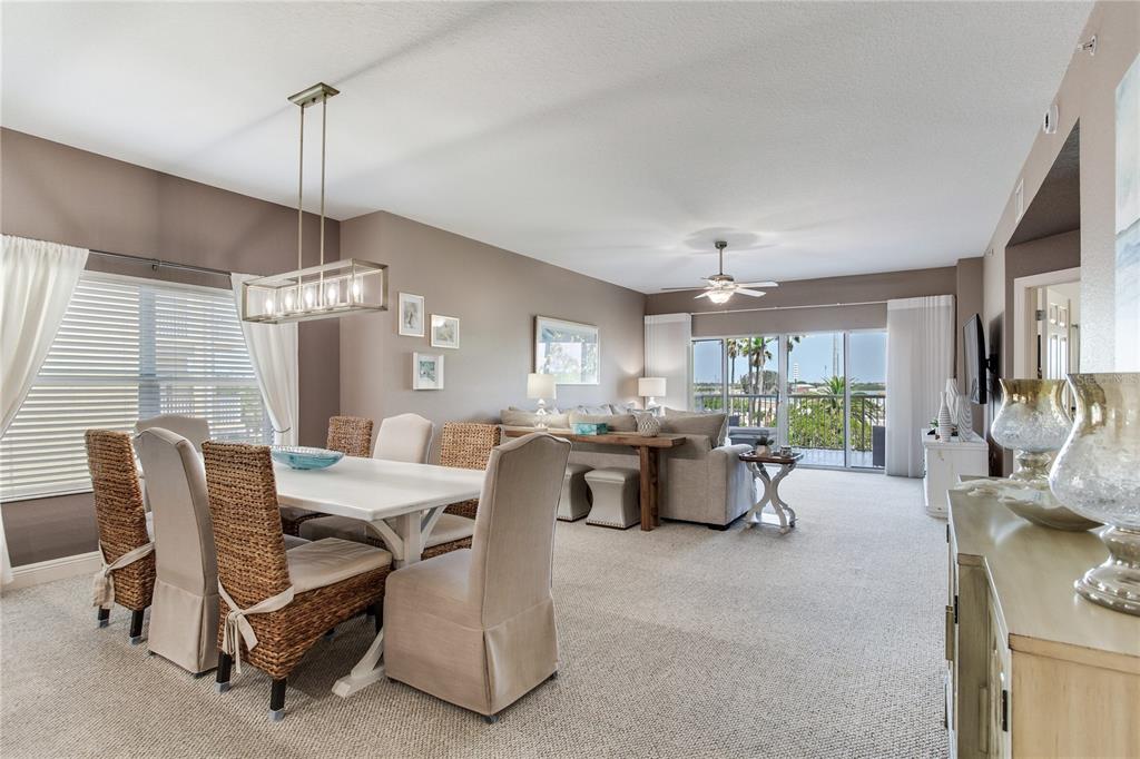 425 150th Avenue, Unit 2301 Madeira Beach, FL 33708 - Photo 9 of 67 a dining room with furniture a chandelier and window