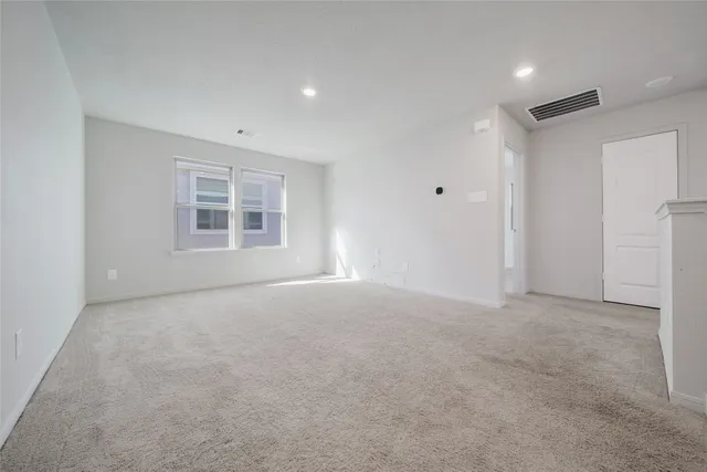 a view of an empty room and chandelier fan