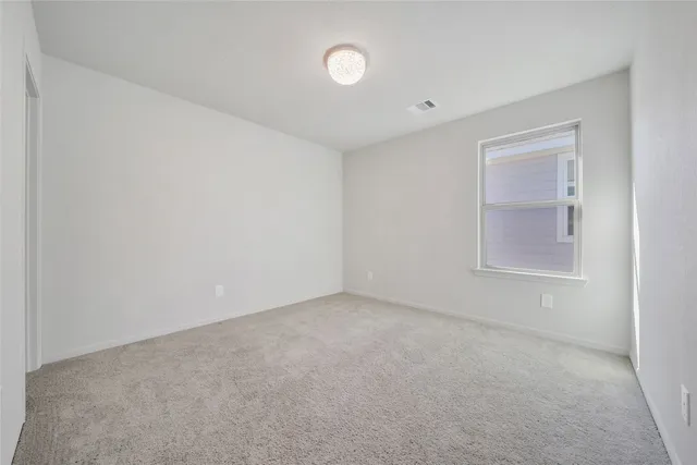 an empty room with closet and windows